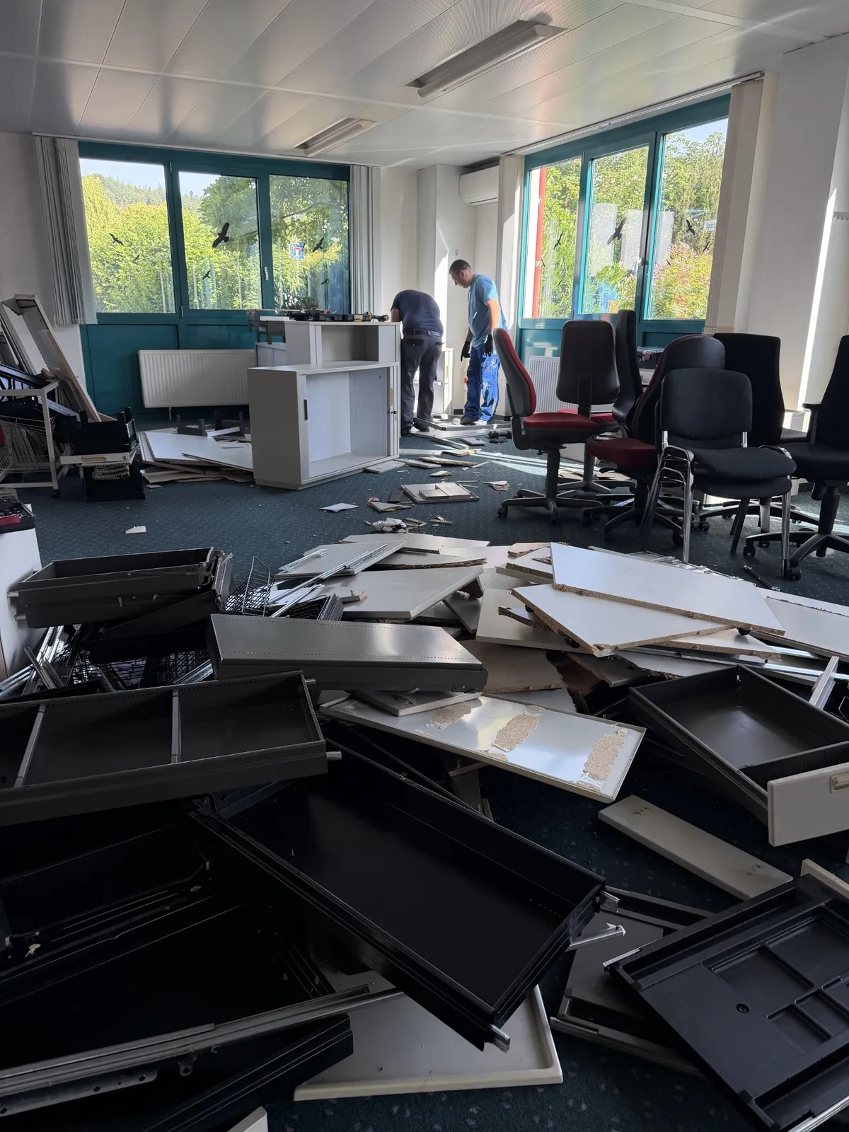 Gewerberäumung in der Praxis: Möbeldemontage in einem Büro – zerlegte Schränke, Schubladen und Bürostühle warten auf den Abtransport