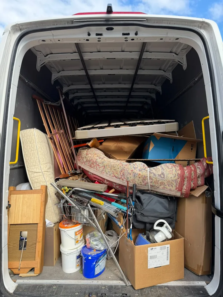 Mitarbeiter von Markgräfler Räumungen belädt einen Transporter mit Kartons und Hausrat bei einer Räumung.